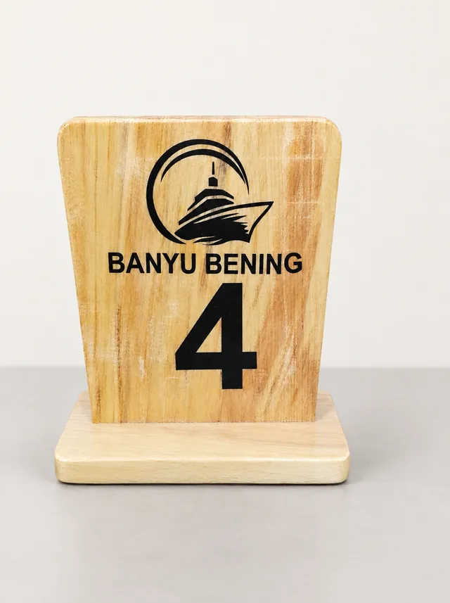 Papan nomor meja dari kayu bertuliskan Banyu Bening nomor 4 di atas alas kayu
