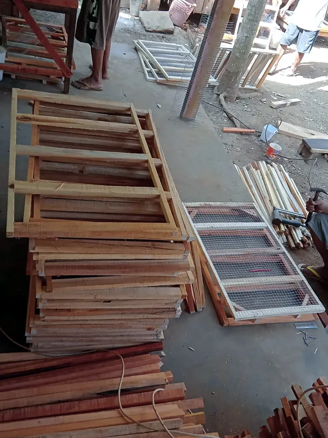 Tumpukan rangka jendela dan bilah kayu di workshop